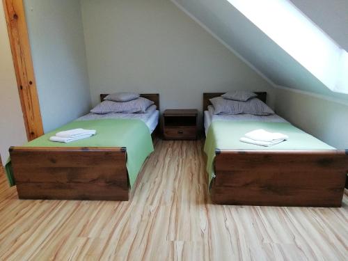 two twin beds in a room with a attic at Zofijówka in Osjaków