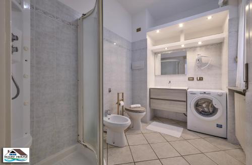 a bathroom with a toilet sink and a washing machine at Mary house lake view in Varenna