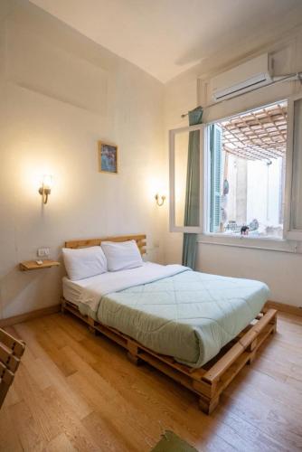 a bedroom with a large bed with a window at Rhala Hostel Egypt in Cairo