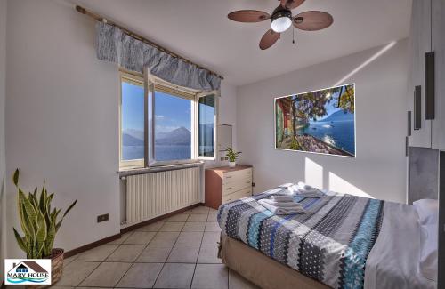 a bedroom with a bed and a large window at Mary house lake view in Varenna
