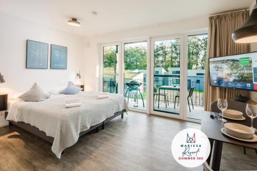 a bedroom with a bed and a tv and a balcony at Marissa Resort in Lembruch