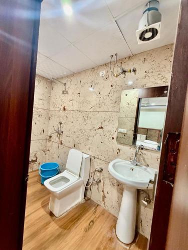 a bathroom with a sink and a toilet and a mirror at Jeevak hotel in Mohali