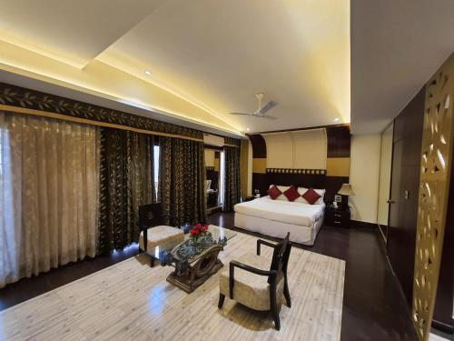 a living room with a bed and a couch at Grand Heritage Narmada Jacksons in Jabalpur