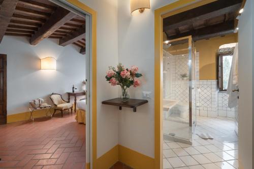 a bathroom with a shower and a vase of flowers at Relais Poggio Borgoni in San Casciano in Val di Pesa