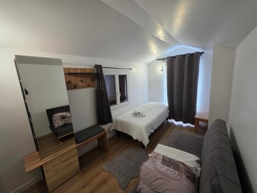 a living room with a bed and a mirror at Maison de ville entièrement équipée in Argenteuil