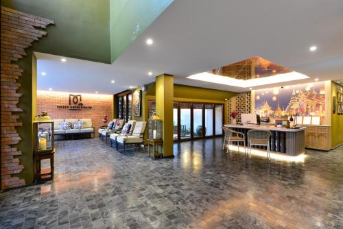 a lobby with couches and tables in a building at March Hotel & Suite Riverside in Chiang Mai