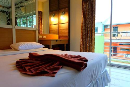 a robe laying on a bed in a room with a window at PSHill in Ao Nang Beach