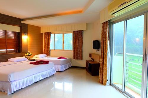 a hotel room with two beds and a large window at PSHill in Ao Nang Beach