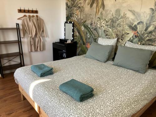 a bed with two pillows on it in a room at Amis Wine House - Maison d'hôtes à 5 min de Saint-Émilion in Pomerol