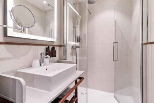 a white bathroom with a sink and a shower at Villa Arthus-Bertrand in Noirmoutier-en-l'lle