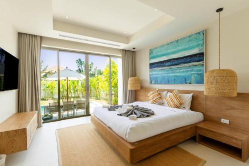 a bedroom with a large bed and a large window at Villa 24 3BR Trichada Breeze in Phuket