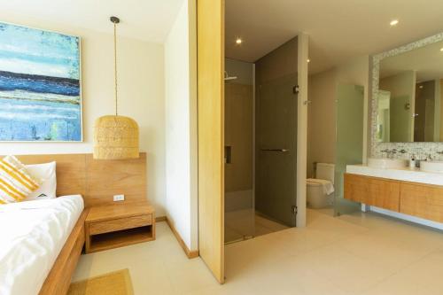 a bathroom with a bed and a shower and a sink at Villa 24 3BR Trichada Breeze in Phuket