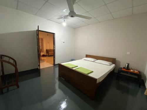 a bedroom with a bed and a ceiling fan at Gloria Cottage Non AC in Negombo