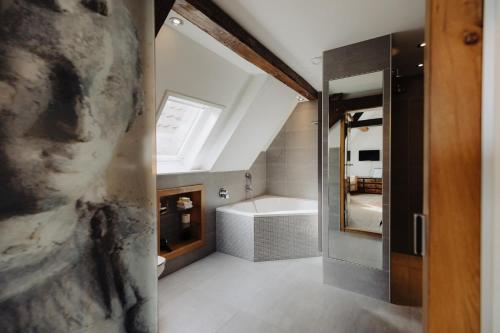 a bathroom with a bath tub and a sink at Hotel De Heeren in Veere