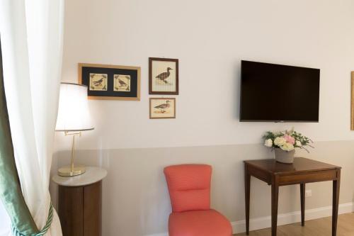 a living room with a tv and a chair at Relais Donna Lucrezia in Rome