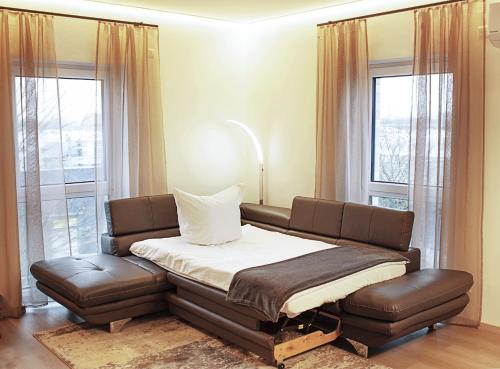 a bed and a couch in a room with windows at Luxuriöse, 1-2-Zimmer-Apartments 30-55 qm in Fürstenau
