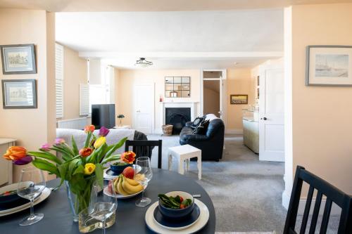a living room with a table with a vase of flowers at Hill House Apartment in Framlingham