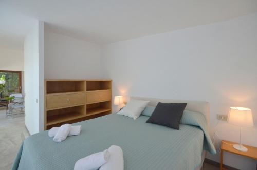 a bedroom with a blue bed with two white towels at Els Llorers - Ref.050 in Begur