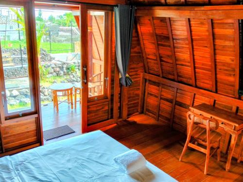 a room with a bed and a desk and a table at Pondok Kayu Canggu in Dalung