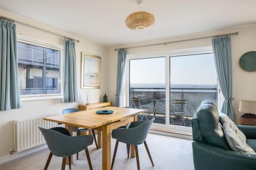 a dining room with a table and chairs and a large window at Island's Edge- Moments from Hamworthy Beach and Park in Poole