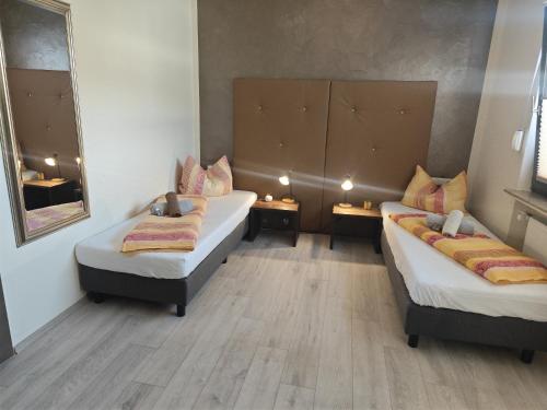 a room with two beds and a mirror at Hotel am Markt Eschweiler in Eschweiler