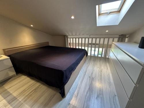 a bedroom with a bed in a room with a window at Cozy Duplex in Arles