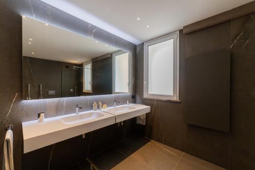 a bathroom with two sinks and a large mirror at Dimora Eledia in Taormina