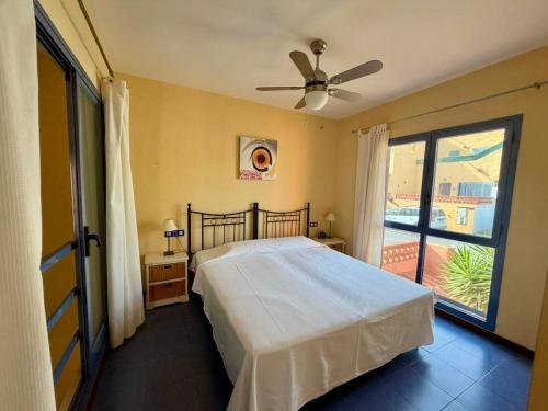 a bedroom with a bed with a ceiling fan at Montaña Blanca - Casa Bimba in Caleta De Fuste