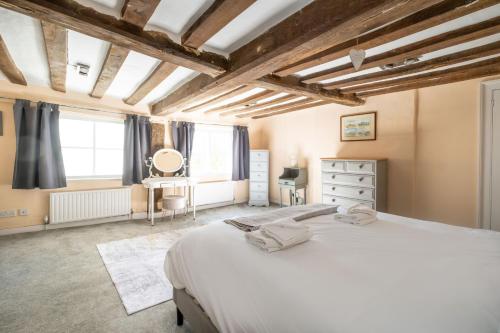 a bedroom with a large white bed and a window at Hill House Apartment in Framlingham