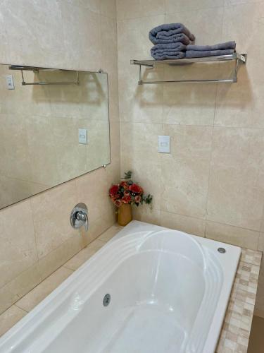 a white tub in a bathroom with a mirror at Villa Serena Garden - Suíte com Hidromassagem - Ideal Casal in Cascavel