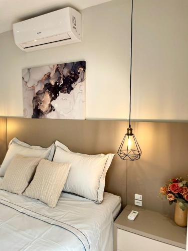 a bedroom with a white bed with a pendant light at Villa Serena Garden - Suíte com Hidromassagem - Ideal Casal in Cascavel