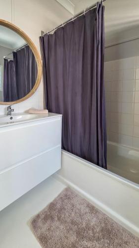 a bathroom with a sink and a shower with a mirror at Harrington Holiday House in Harrington