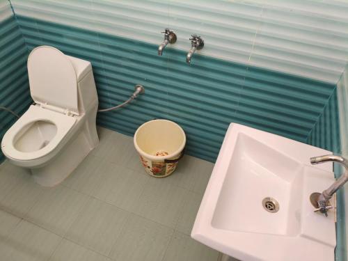 a bathroom with a toilet and a sink at Sai Devine Abode Of SAI at Sri Sathya Sai ghaat in Rishīkesh