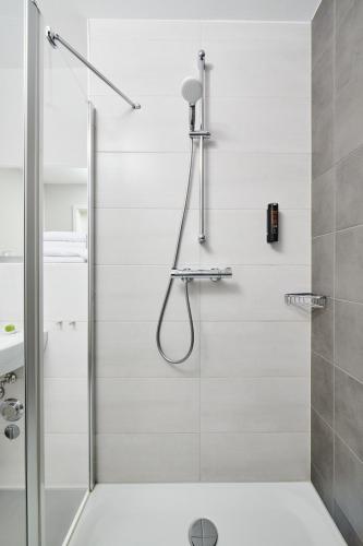 a shower with a glass door in a bathroom at ADAPT APARTMENT HOTEL Wetzlar in Wetzlar