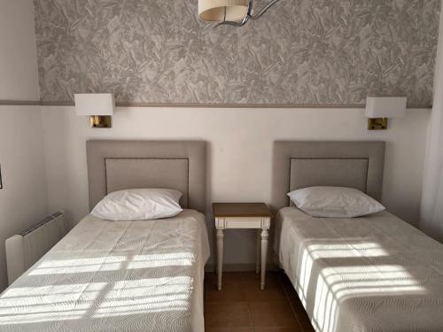 two beds sitting next to each other in a room at Casa do Limoeiro - Casa in Golegã