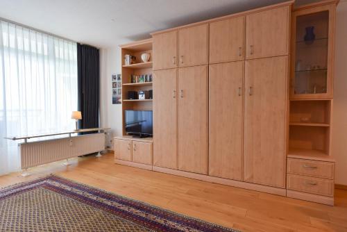 a living room with wooden cabinets and a television at Haus "Panorama" Appartement PAN019 in Duhnen