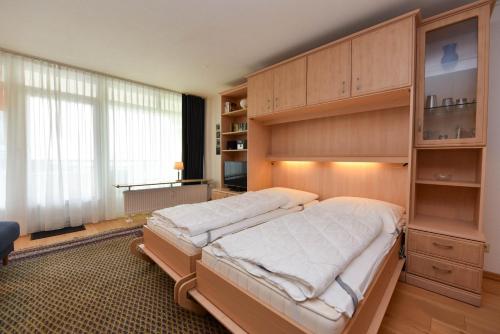 a bedroom with a large bed and a large cabinet at Haus "Panorama" Appartement PAN019 in Duhnen