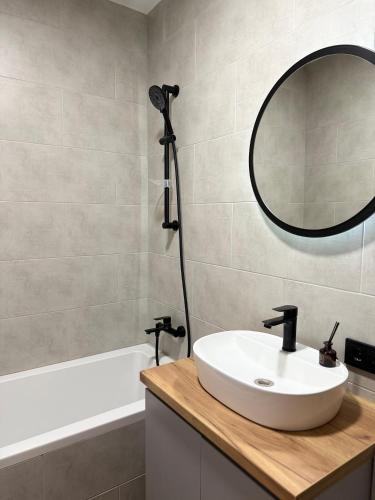 a bathroom with a sink and a mirror and a tub at Apartment in Irpin Pavlenka in Irpin