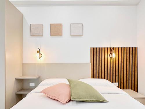 a bedroom with two beds with white sheets and pink pillows at Florida Apartments in San Vincenzo