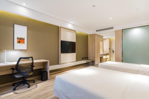 a hotel room with two beds and a desk at Atour Hotel Maqun Nanjing in Nanjing