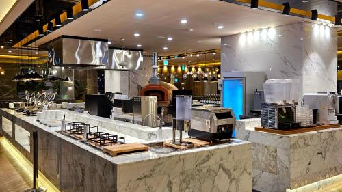 a large kitchen with a counter in a restaurant at SainTree Hotel in Incheon