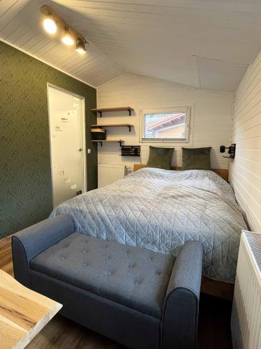 a small bedroom with a bed and a blue bench at Ferienhaus Elda in Lahnstein