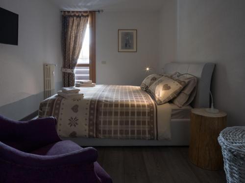 a bedroom with a bed and a window at Casa Beba in Bormio