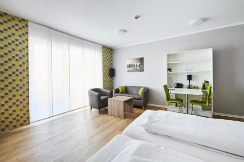 a hotel room with a bed and a desk and chairs at ADAPT APARTMENT HOTEL Wetzlar in Wetzlar