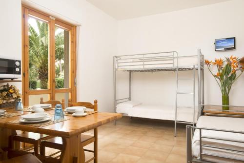 a dining room with a table and a bunk bed at Residence Oasis in Alghero
