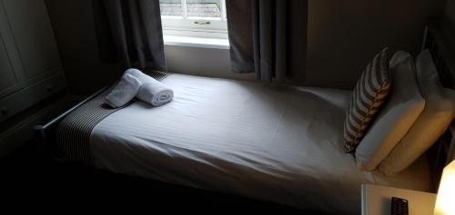 a bedroom with a bed with two towels on it at The Grapes in Southampton