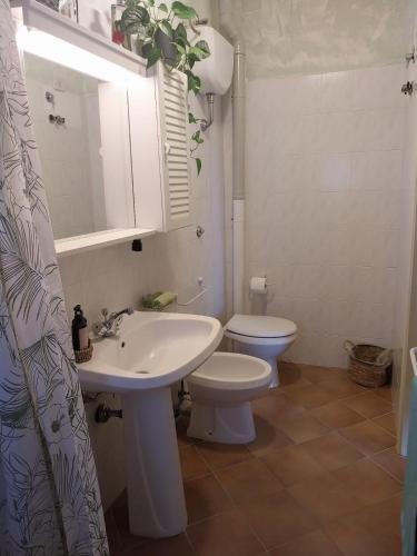 a bathroom with a white sink and a toilet at Casa Carini in Scansano