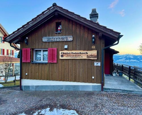 a building with a sign on the side of it at Panorama-Chalet Unterbach in Hinwil