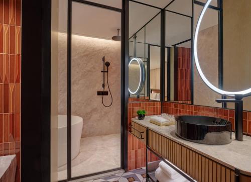 a bathroom with a tub and a sink and a mirror at Hyatt Centric The Ring Chengdu in Chengdu