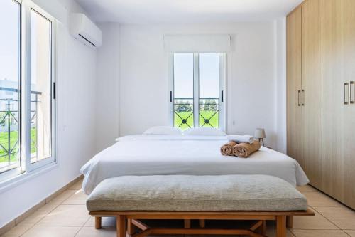 a white bedroom with a large bed and a window at 2BR Apartment with Amazing View and Pool in Kiti in Kiti